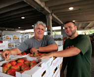 Two men looing at a crate of produce